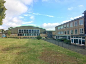 Photo of The Halley Academy building taken from a green space on the academy grounds.
