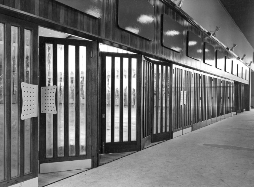 Black and white photo of the set of doors at the entrance to the main hall inside The Halley Academy building.